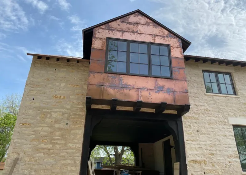 Copper metal panel facade on a stone building for Skylight Installation in La Crescent